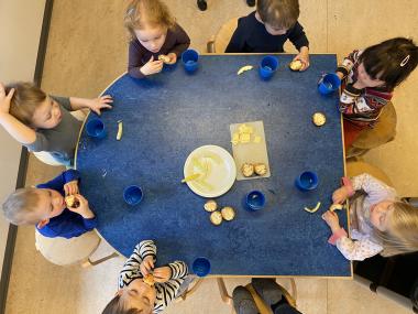Børn der sidder rundt om bordet og spiser formiddagsmad